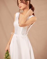 Silk sleeveless V-neck gown with lace-up side detail and full-length flowing A-line skirt